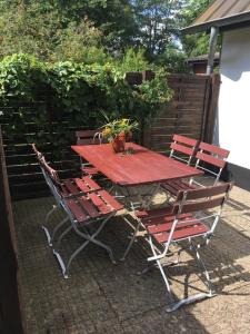 a red picnic table and chairs on a patio at Ferienhaus Knorburg im Herzen Nordfrieslands in Enge-Sande