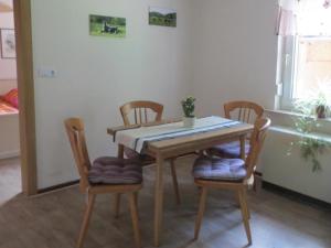 uma mesa de jantar com quatro cadeiras e uma mesa em Ferienhaus in ruhiger Lage in der Nähe zahlreicher Wanderrouten, Reitmöglichkeit em Wutha-Farnroda