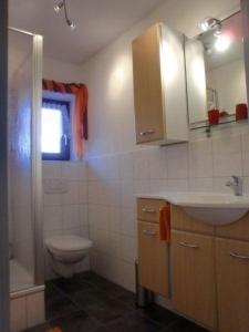 a bathroom with a toilet and a sink and a shower at Ferienwohnung in Grafing Bei München mit Großem Garten in Grafing