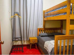 um quarto com um beliche e um tapete vermelho em Acogedor Suite en Moyobamba - Medellín House I em Moyobamba