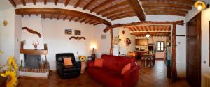 un soggiorno con divano rosso e camino di Private toskanische Villa mit Pool und Whirlpool in der Nähe von Siena a San Dalmazio