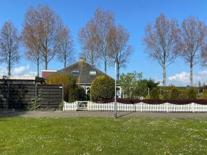 a white picket fence in front of a house at Ferienhaus für 4 Personen ca 65 m in Stavenisse, Zeeland Tholen in Stavenisse