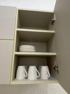 ein Schrank mit weißen Tassen und Platten in der Unterkunft Mini apartamento en Ayacucho in Ayacucho