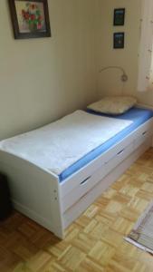 a white bed in a room with a wooden floor at Wohnung in Pidingerau mit Großer Terrasse in Piding