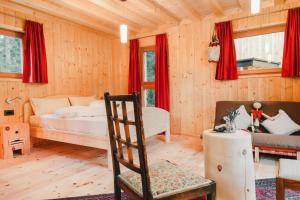 sypialnia z łóżkiem i krzesłem w pokoju w obiekcie Ferienhaus in Zona Artigianale San Felice mit Grill und Terrasse w mieście Tret