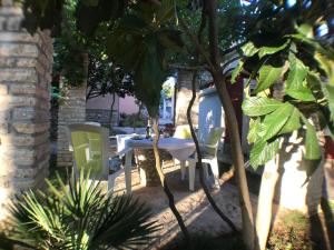 een patio met een tafel en stoelen onder een boom bij Strandnahes, kleines Ferienhaus mit schattiger Terrasse und Gartennutzung, ruhig gelegen in der Nähe von Zadar in Bibinje