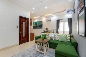 a living room with a green couch and a table at Prague Hotel Vung Tau in Vung Tau