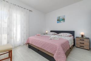 a bedroom with a bed with a pink blanket at Apartments with a parking space Makarska - 21823 in Makarska