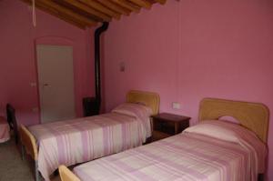 3 camas en una habitación con paredes rosas en Ferienwohnung für 4 Personen 1 Kind ca 80 qm in Campiglia Marittima, Toskana Etruskische Küste, en Campiglia Marittima