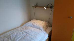 a small room with a bed with a light on it at SCHELP Bed by the Sea in Westkapelle