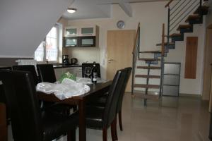 una sala da pranzo con tavolo, sedie e scala di Wohnung in Rowy mit Grill, Terrasse, Parkplatz und Garten a Rowy