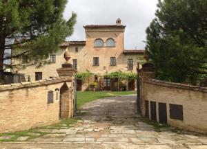 an external view of a large brick building with a gate at Ferienhaus in Piosina mit Garten, Whirlpool und Grill in Città di Castello