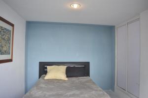 Monkstel Puebla في Momoxpan: سرير في غرفة ذات جدار ازرق