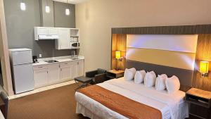 um quarto de hotel com uma cama e uma cozinha em Southfort Inn em Fort Saskatchewan
