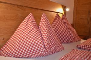 a group of four red and white pillows on a bed at Modernes Appartement vor herrlicher Gebirgskulisse mit zwei Balkonen und Kamin in Umhausen