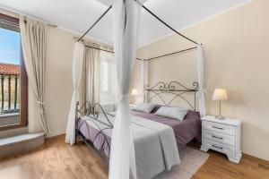 a bedroom with a canopy bed and a window at Charmantes Ferienhaus in Svetvinčenat mit Privatem Pool in Svetvinčenat