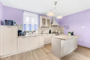 a kitchen with white cabinets and purple walls at Charmantes Ferienhaus in Svetvinčenat mit Privatem Pool in Svetvinčenat +14 photos