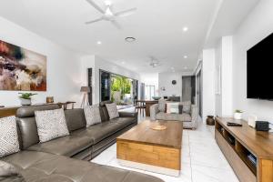a living room with a couch and a flat screen tv at A Perfect Stay - Ray of Sunshine in Gold Coast