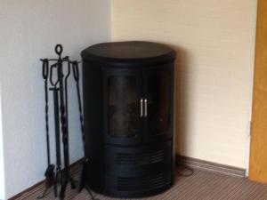 a black fireplace in the corner of a room at Charmantes Ferienhaus in Bleckede-Breetze mit Großem Garten in Bleckede