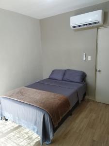 1 dormitorio con 1 cama y aire acondicionado en Casa Vacacional 2 Pisos, en Mazatlán