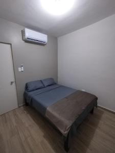 1 dormitorio con 1 cama y aire acondicionado en Casa Vacacional 2 Pisos, en Mazatlán