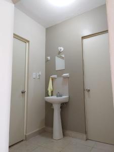 a white bathroom with a sink and a shower at Casa Vacacional 2 Pisos in Mazatlán