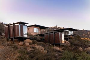 un groupe de maisons assises au sommet d'une colline dans l'établissement Villa Garven @ R. Encuentro Guadalupe, à Valle de Guadalupe