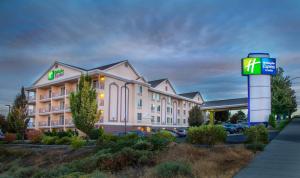 un hôtel avec un panneau devant un bâtiment dans l'établissement Holiday Inn Express Hotel & Suites Richland, à Richland