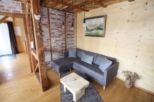 a living room with a couch and a table at Ferienhaushälfte Gösselberg im Ferienhaus Anno Dazumal, wie zu Großmutters Zeiten, linke Seite in Klingenthal