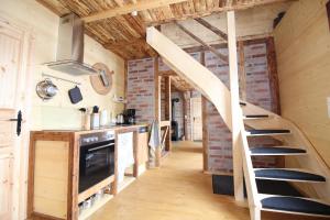 a kitchen with a staircase leading up to a loft at Ferienhaushälfte Gösselberg im Ferienhaus Anno Dazumal, wie zu Großmutters Zeiten, linke Seite in Klingenthal +14 photos