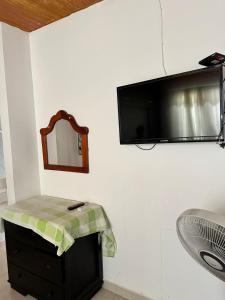 uma casa de banho com um espelho e um lavatório e uma televisão na parede em Habitación temporada festival em Valledupar
