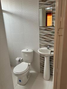 uma casa de banho branca com um WC e um lavatório em Habitación temporada festival em Valledupar