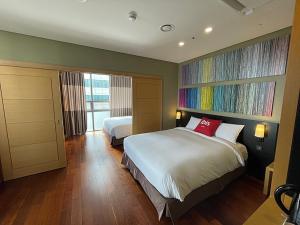 1 dormitorio con 2 camas y una gran pintura en la pared en Ibis Ambassador Busan City Centre en Busan