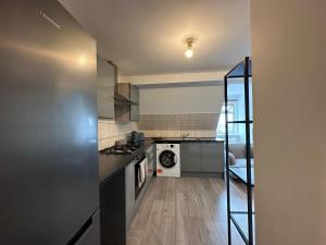 a kitchen with a stove and a washer at Wembley Stadium Serviced Apartments, 12mins to Central London in London