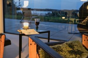 a table with a candle and a glass of wine at Haus am See Storkow in Storkow