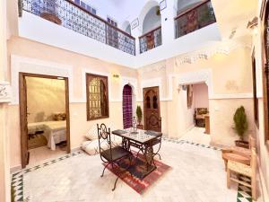 Habitación grande con mesa y dormitorio. en Riad Des Sables, en Marrakech