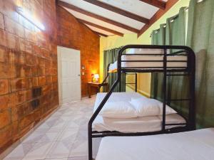 1 dormitorio con 2 literas y pared de ladrillo en Años Dorados - Casa rústica a 200 mts de la Playa Punta Chame, en Punta Chame