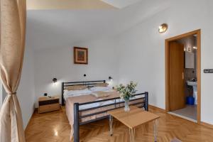 ein Schlafzimmer mit einem Bett und einem Tisch mit einer Vase darauf in der Unterkunft Gästezimmer für zwei Personen mit Balkon in Duće