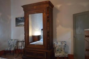 um grande espelho de madeira num quarto com duas cadeiras em Ferienwohnung für 4 Personen ca 95 qm in Monteriggioni, Toskana Chianti em Monteriggioni