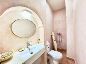 un bagno con lavandino, water e specchio di Riad La Rose Des Sables a Marrakech