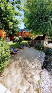 a yard with two chairs tied to a tree at cabaña junto al arroyo in San Martín de los Andes