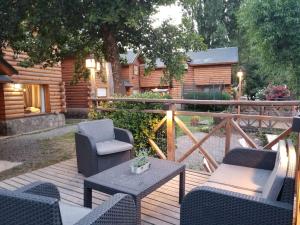 a wooden deck with chairs and a table at cabaña junto al arroyo in San Martín de los Andes