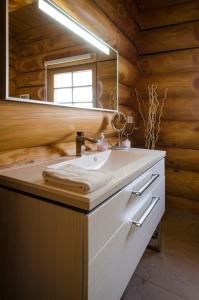 La salle de bains est pourvue d'un lavabo et d'un miroir. dans l'établissement Ferienhaus in Feldberg Schwarzwald mit Privatem Pool, à Neuglashütten