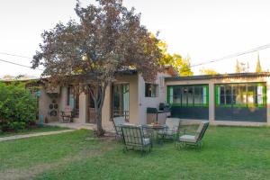 a house with a table and chairs in the yard at Besares 722 in Chacras de Coria