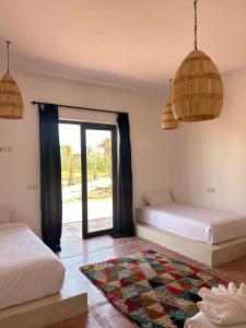 um quarto com 2 camas e uma janela em Aghmat Lodge Guest house em Marrakech