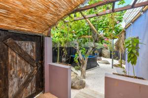 Zugang zu einem Gewächshaus mit einer Holztür in der Unterkunft Mammaloe in Oranjestad