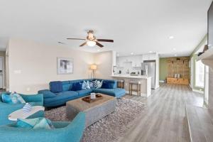 a living room with blue couches and a kitchen at The Heather Marie - Stylish and Modern Rambler in Panama City