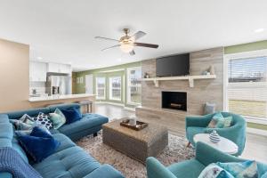 a living room with blue couches and a fireplace at The Heather Marie - Stylish and Modern Rambler in Panama City
