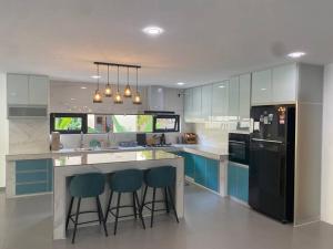 a kitchen with two bar stools at a kitchen counter at Casa al Mare Andaman Hills Villa in Pantai Cenang