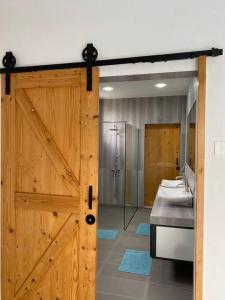 a bathroom with a wooden door and three sinks at Casa al Mare Andaman Hills Villa in Pantai Cenang